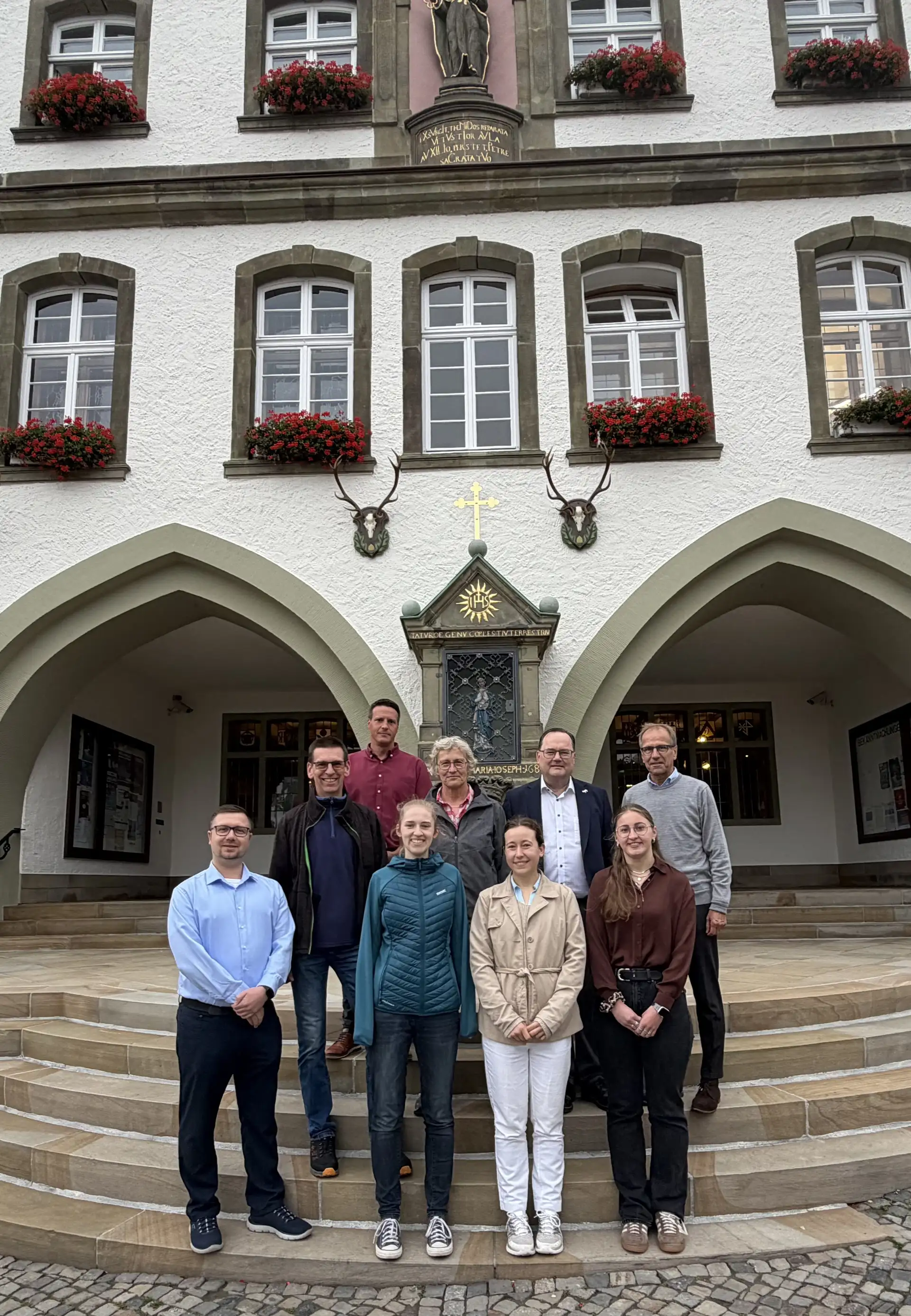Gruppenfoto mit mehreren Personen, darunter zwei Medizinstudentinnen, in einem gemeinsamen Porträt.