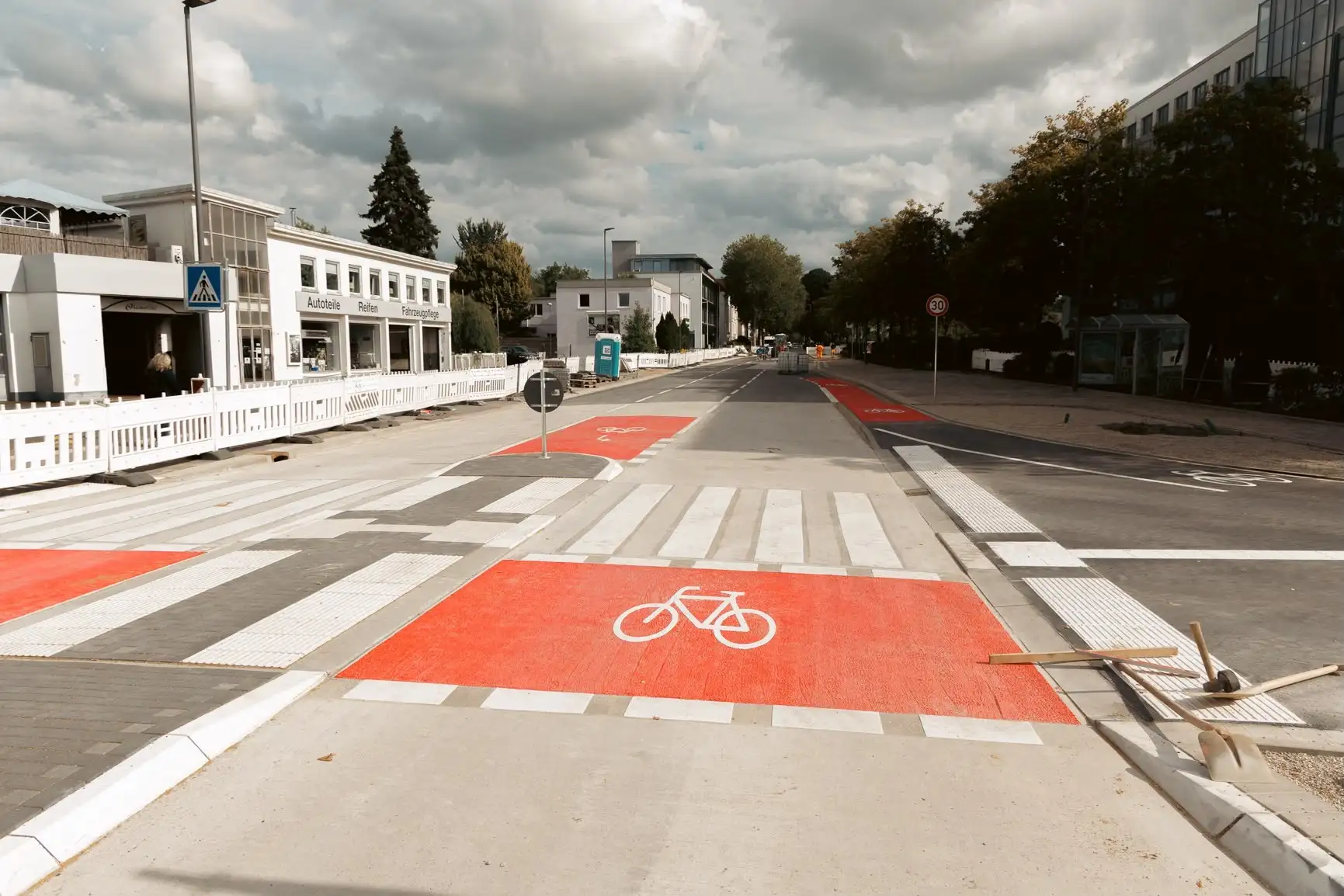 Blick auf einen Radwegabschnitt mit Markierungen und Beschilderung in der Stadt.