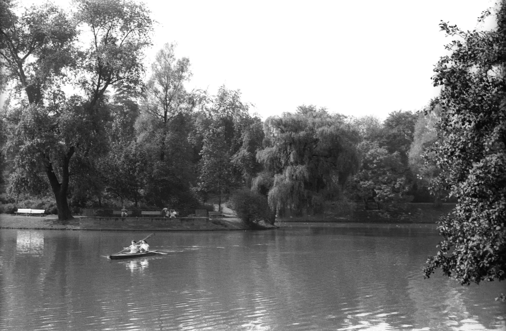 Kanu auf dem Gondelteich im Stadtpark, Schwarzweißaufnahme mit Bäumen und Ufer im Hintergrund.