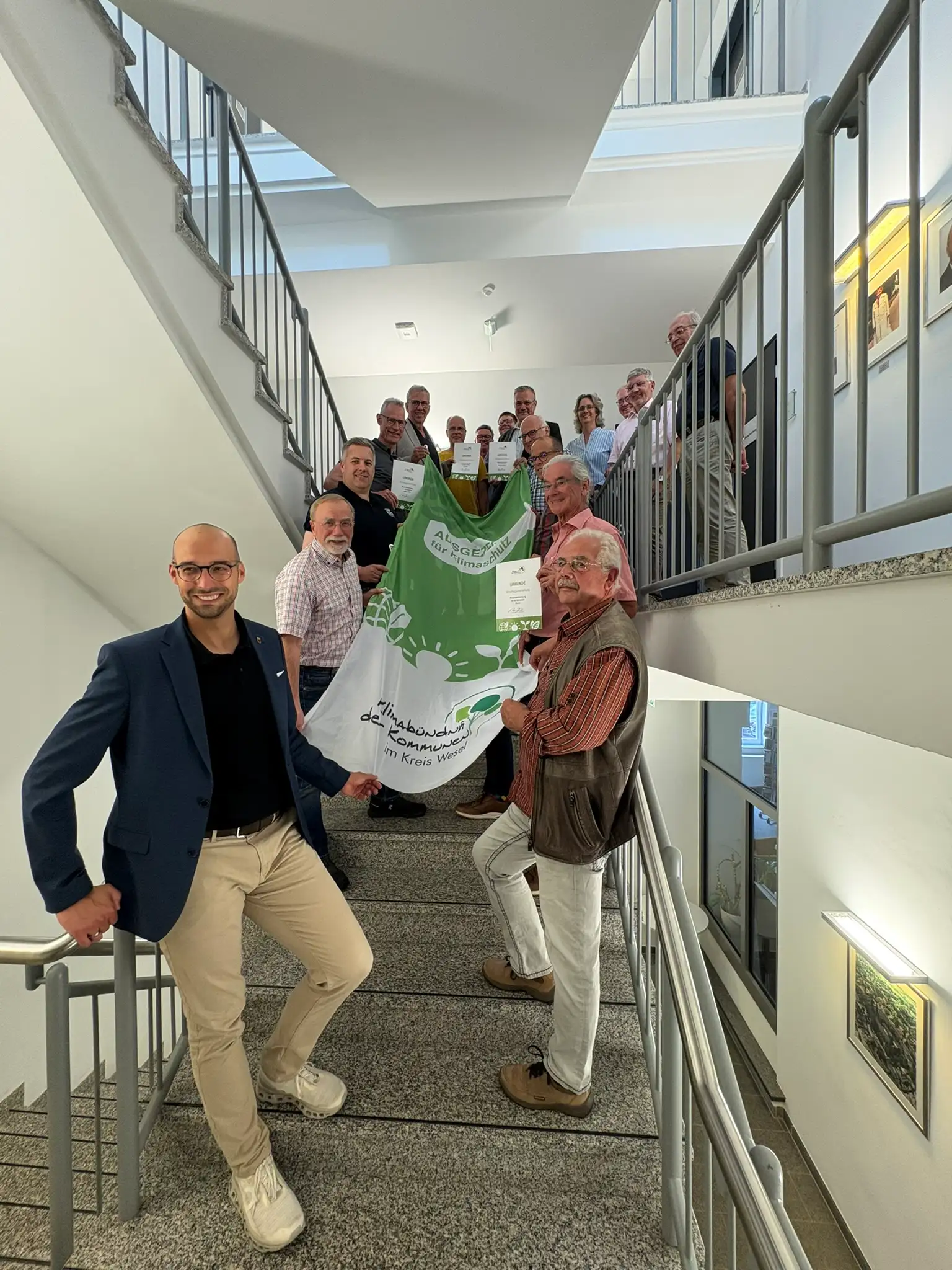 Klimaflagge im Wind mit sichtbarem Schriftzug.