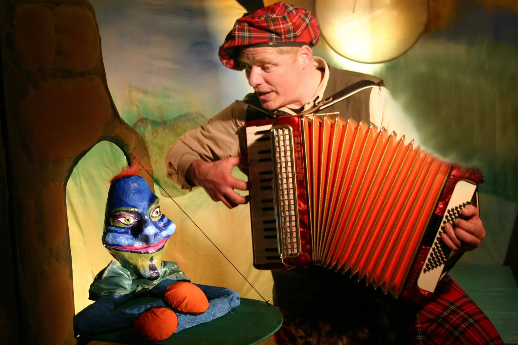 Kindertheater-Bühnenbild „Froschkapelle“ mit Figuren/Kulisse und Publikum oder Mitwirkenden im Vordergrund.