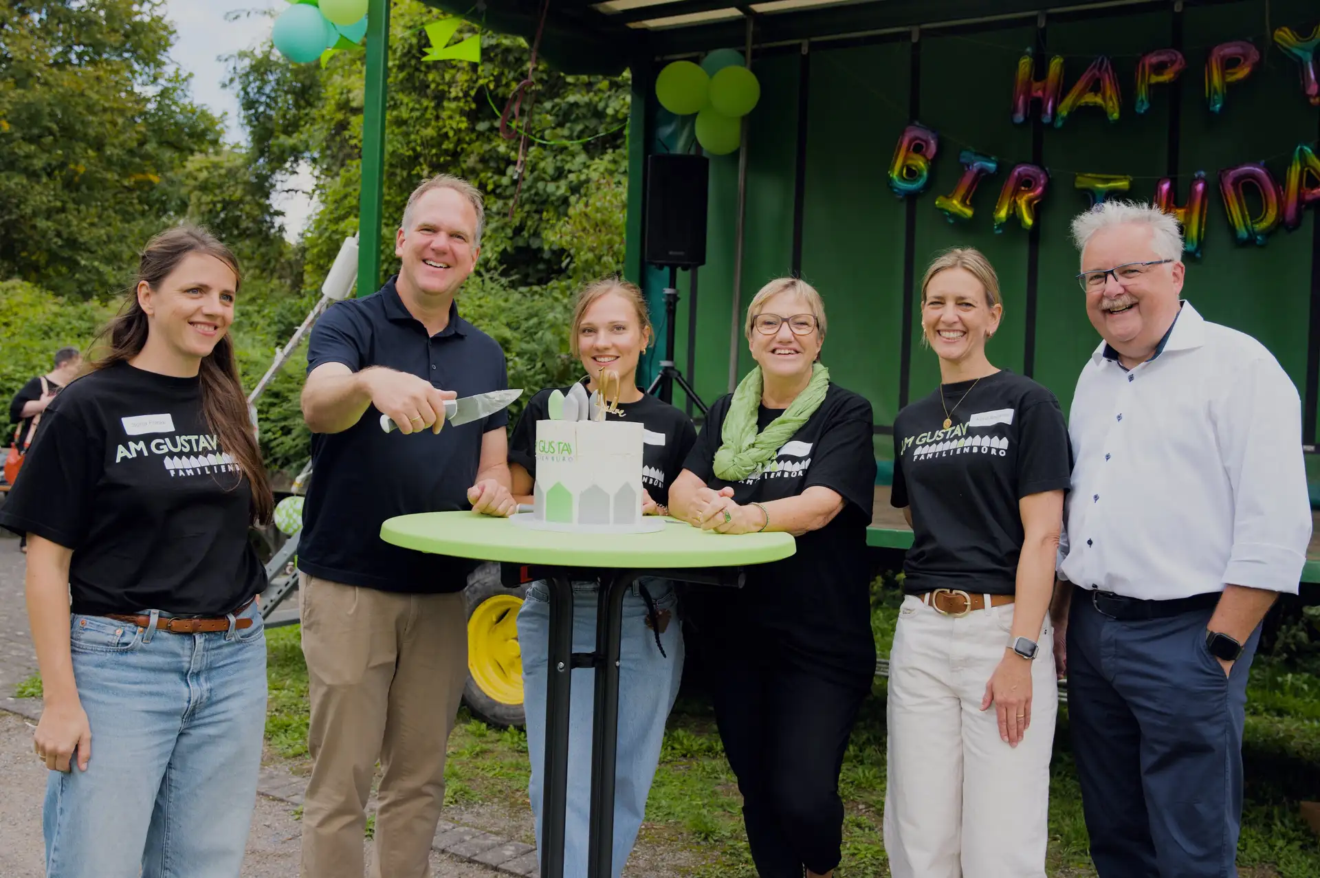 Bürgermeister Dirk Breuer schneidet die Geburtstagstorte an. Mit da- bei sind (von links) Sonja Franke, Katharina Sengersdorf, Petra Annen-Waizner und Astrid Bodamer vom Familienbüro sowie Thomas Klug, Vorsitzender des Jugendhil- feausschusses. Bild: Stadt Hürth