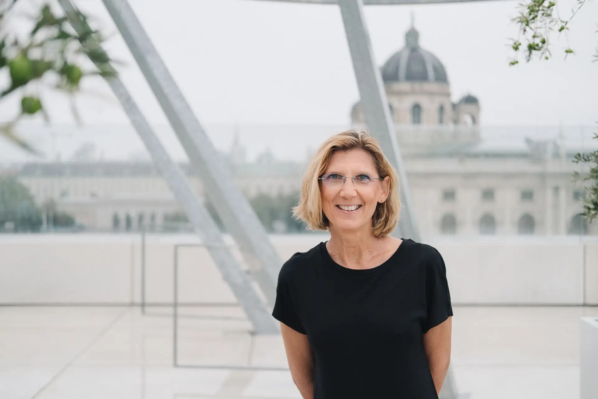Portrait einer sitzenden Frau mit Mikrofon bei einer Veranstaltung.