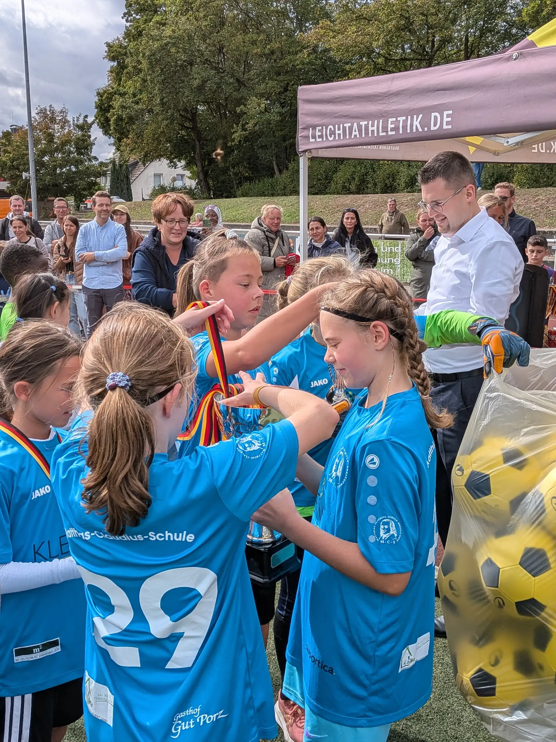 Zwei Personen bei der Siegerehrung mit Wanderpokal bzw. Trophäe.