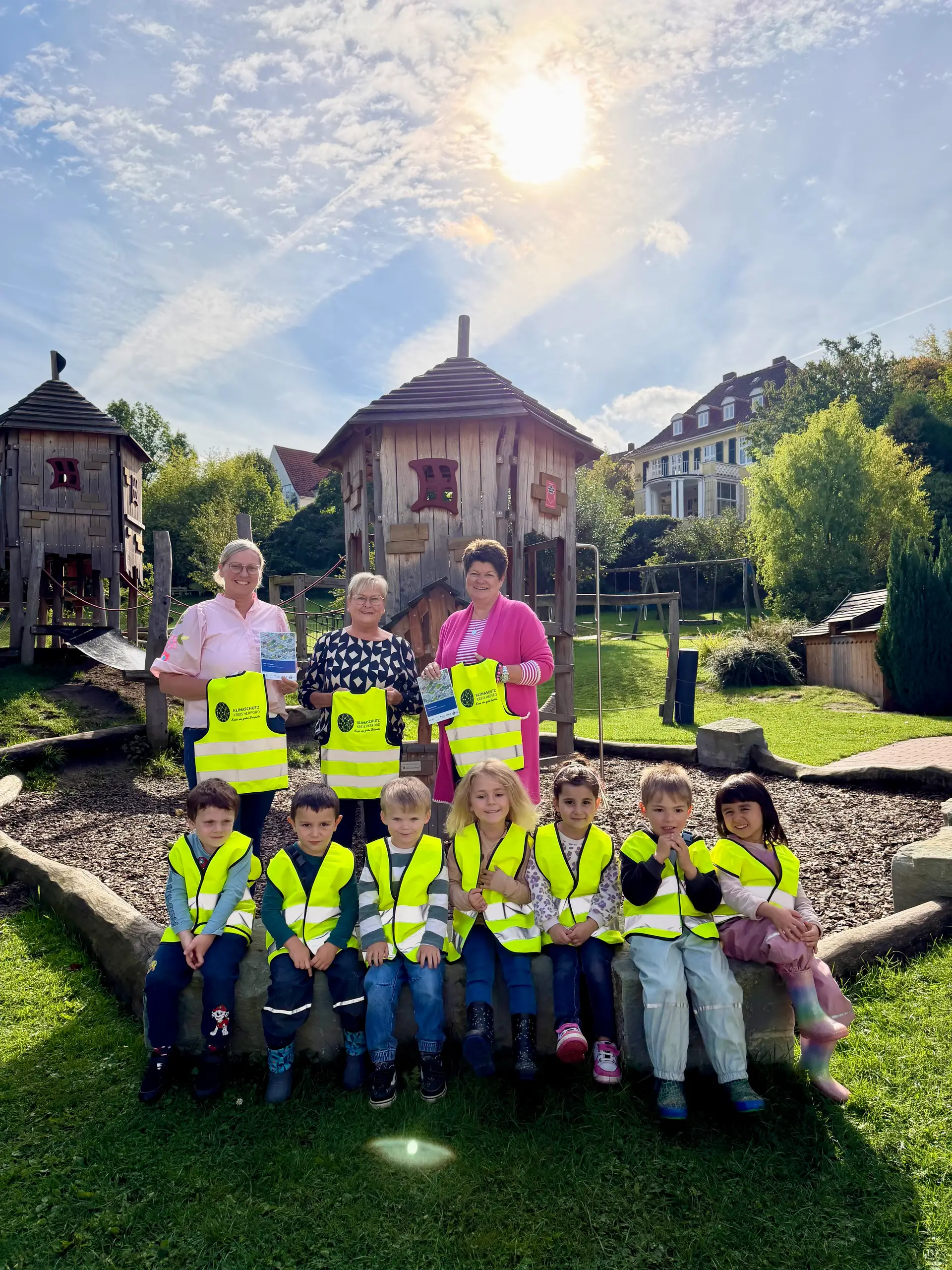 Personen übergeben bzw. präsentieren Verkehrssicherheitswesten für Kinder.