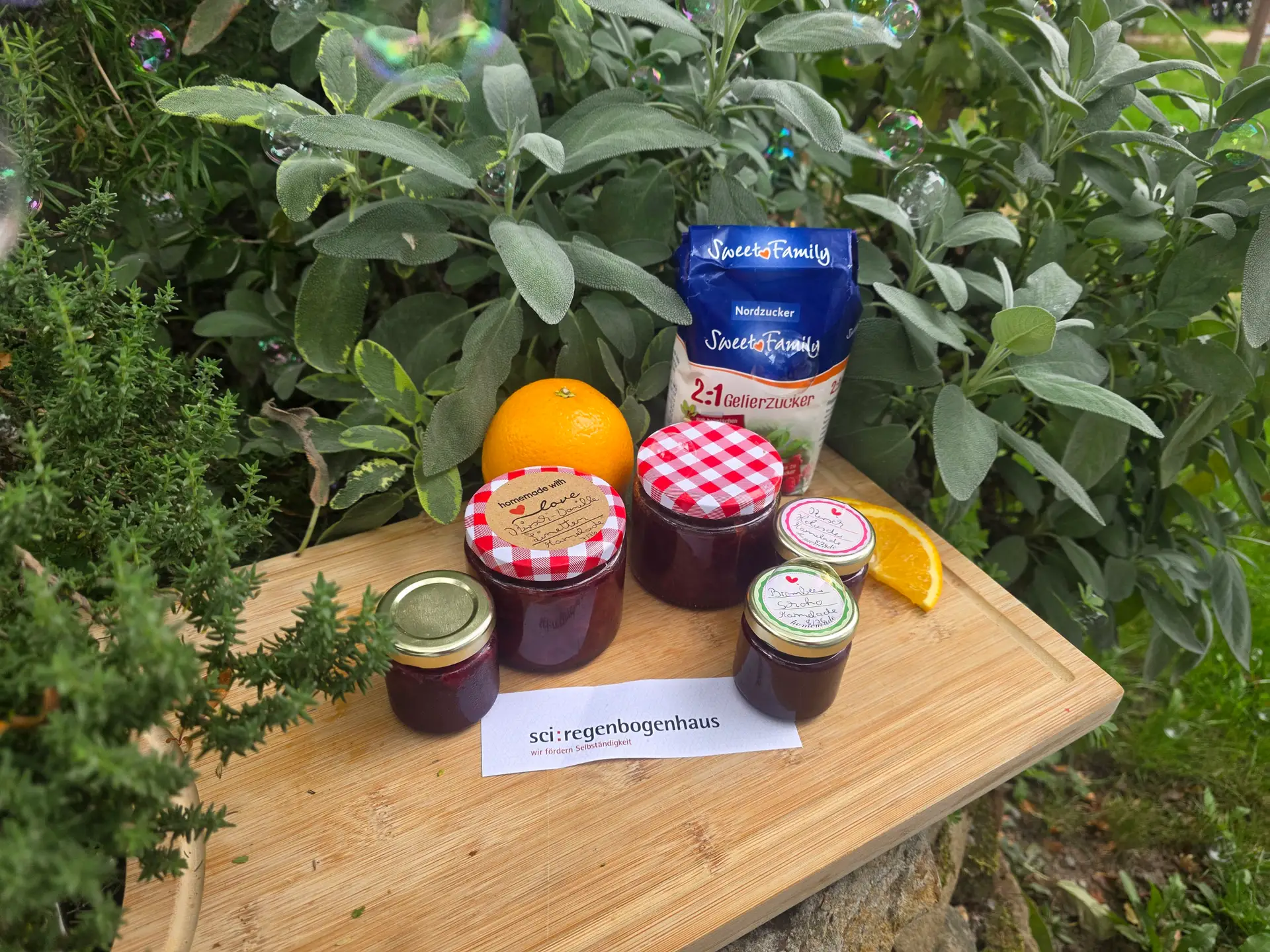Auf einem Wochenmarkt werden eingekochte Marmeladen zum Probieren bereitgestellt.