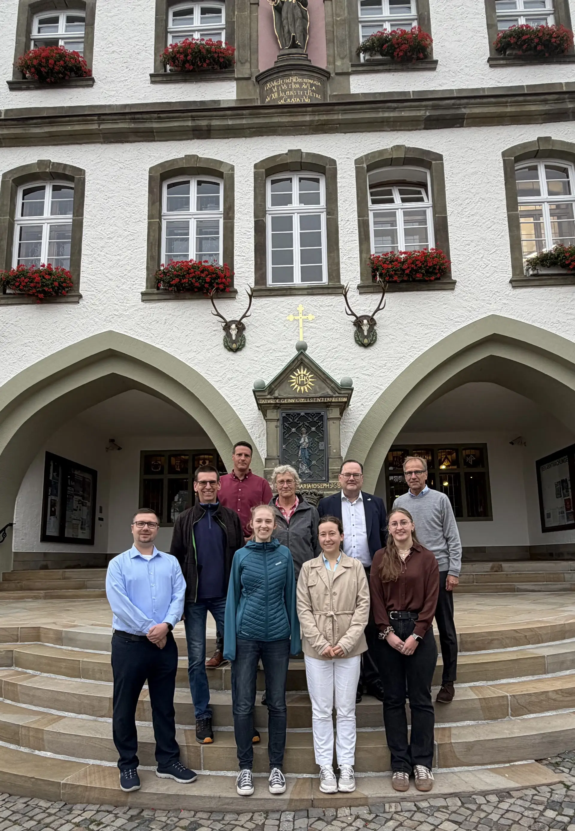 Gruppenfoto mit mehreren Personen, darunter zwei Medizinstudentinnen, in einem gemeinsamen Porträt.