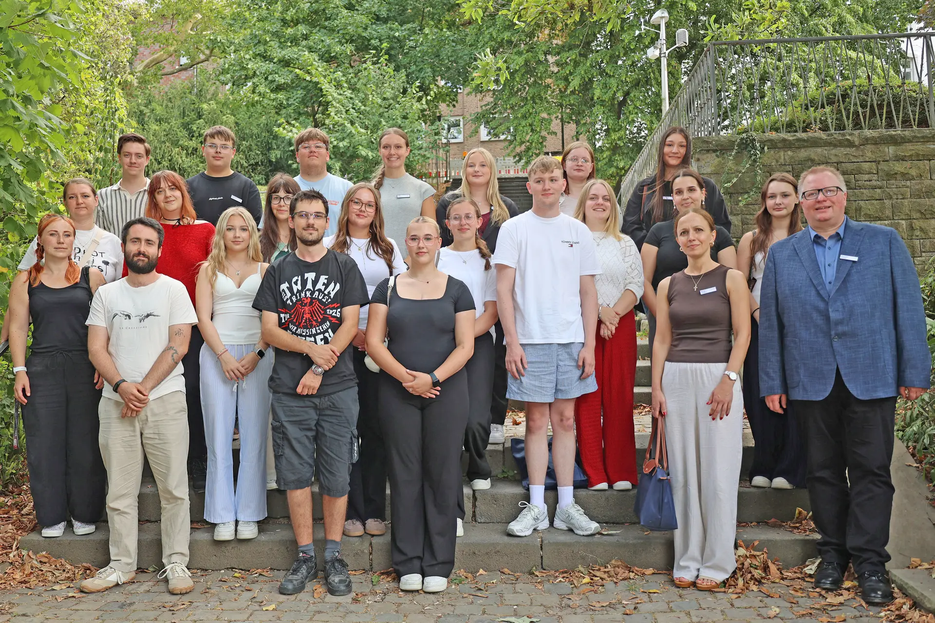 Gruppenfoto von Nachwuchskräften vor Kita-Gebäuden