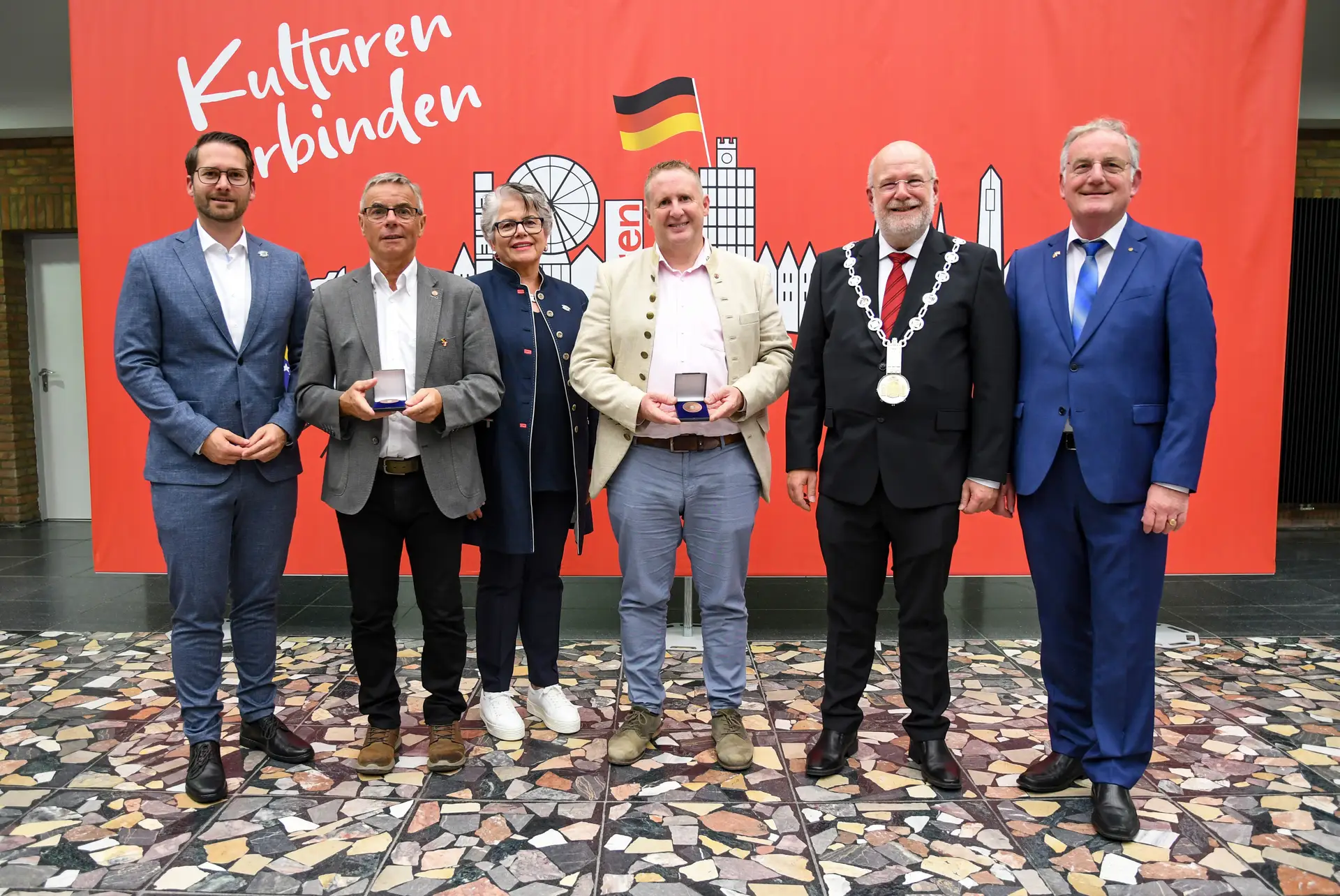 Personengruppe bei einer Veranstaltung zur Verleihung von Ehrenplaketten.
