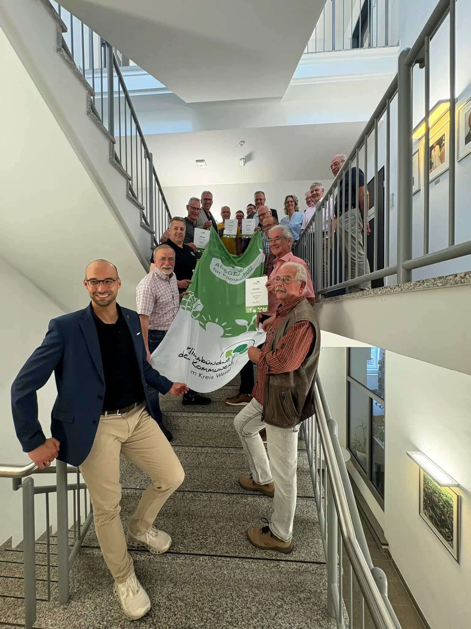Klimaflagge im Wind mit sichtbarem Schriftzug.
