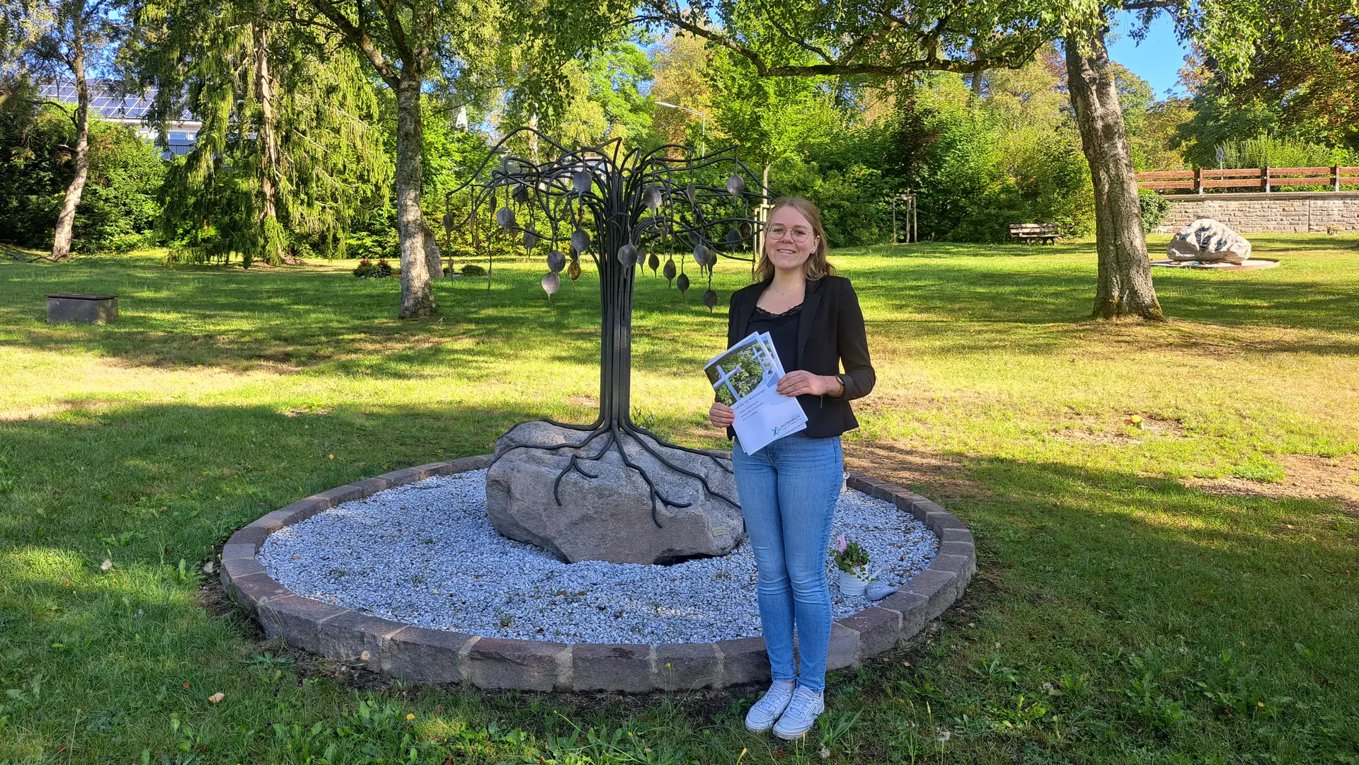 Lisa Marie Leopold, Mitarbeiterin der Stadtverwaltung, präsentiert die neue Friedhofsbroschüre für Hilchenbach. Auf dem alten Friedhof in Hilchenbach besteht die Möglichkeit einer Urnenparkbestattung. Beispielsweise ist für jeden Verstorbenen ein Bronzeblatt am Trauerbaum vorhanden. 2 F:\Anw32\Word2000\normal.dot F:\Anw32\Word2000\normal.dot