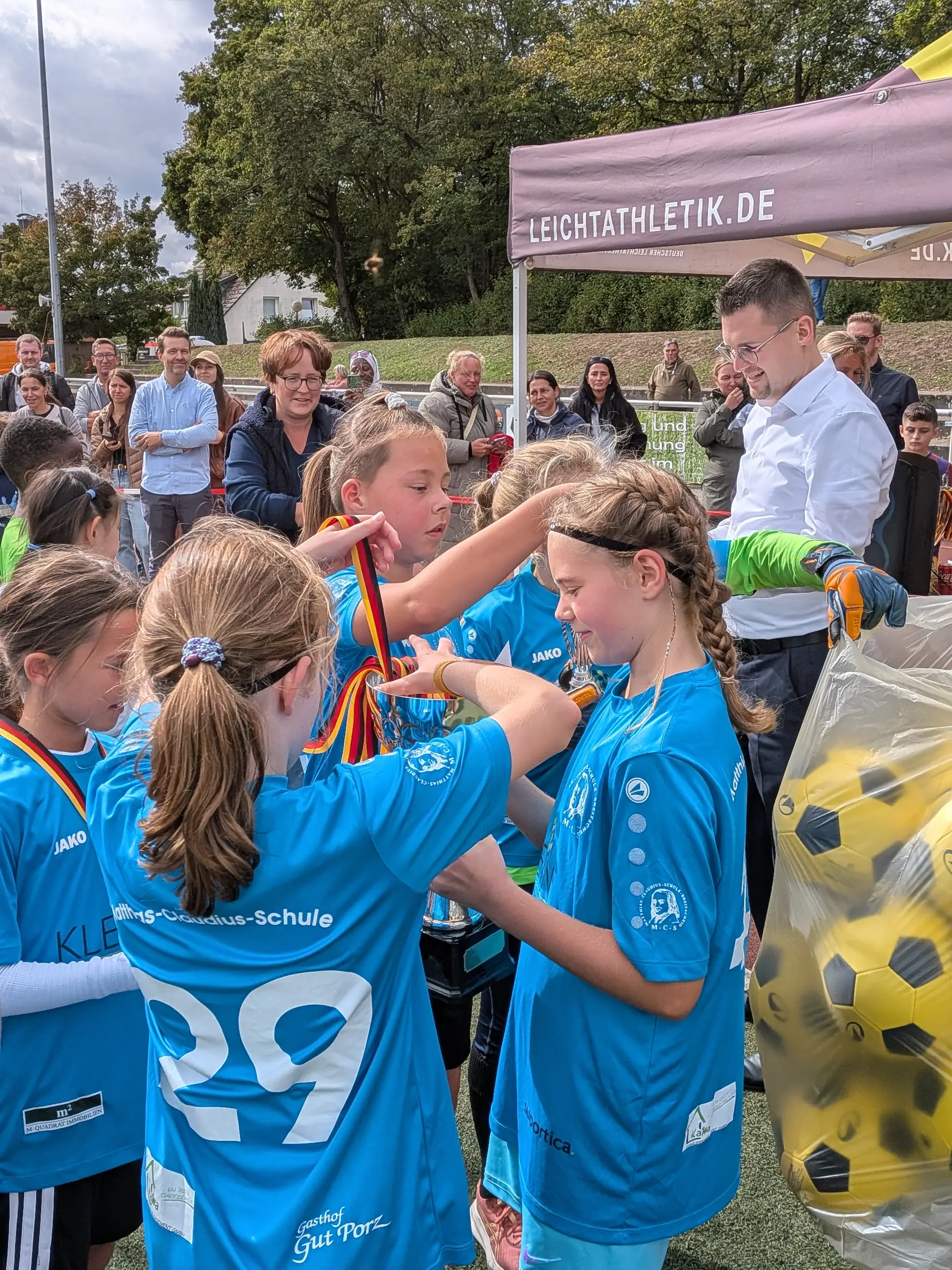 Zwei Personen bei der Siegerehrung mit Wanderpokal bzw. Trophäe.