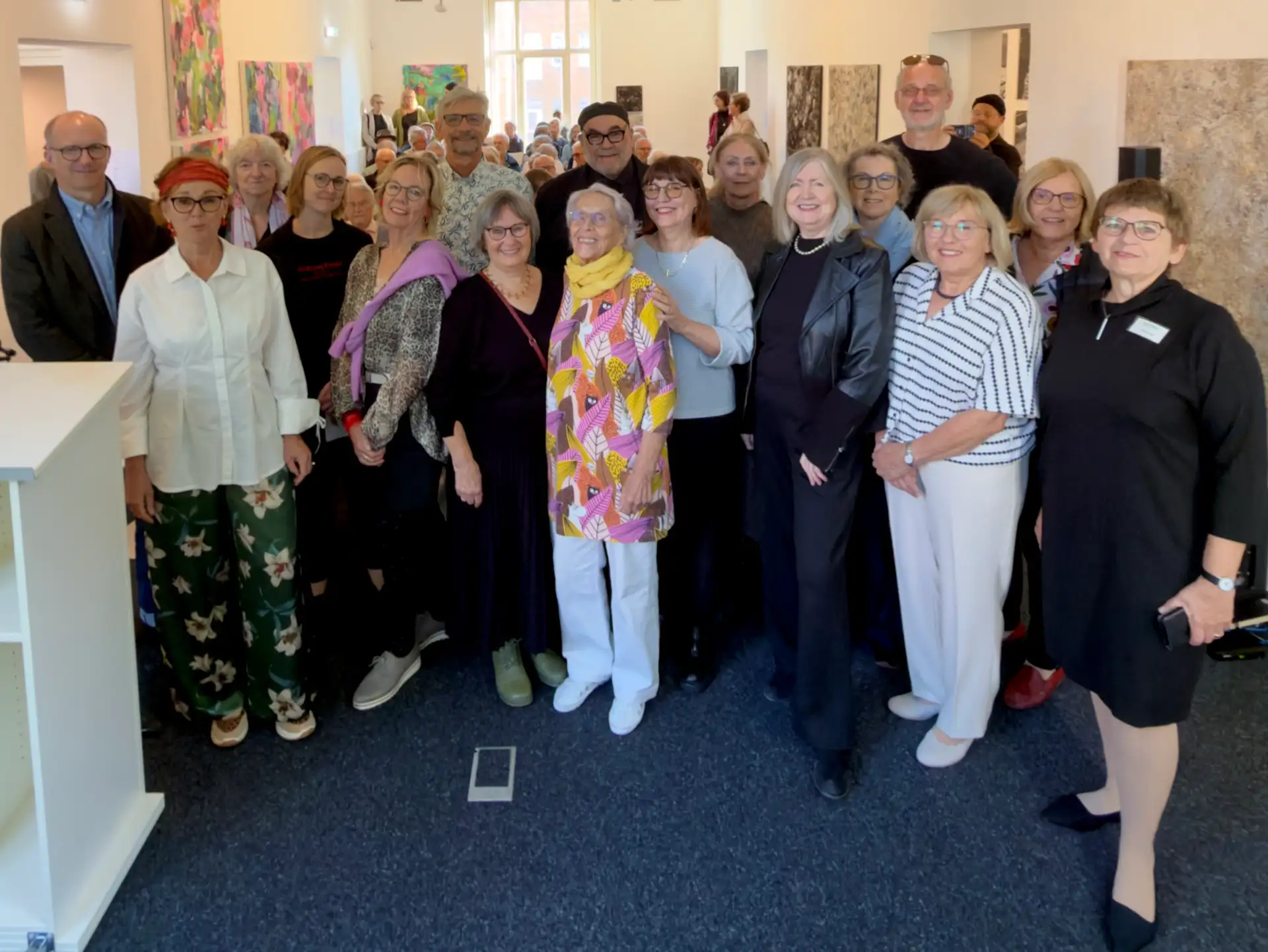 Gruppenfoto von mehreren Personen bei einer Eröffnungsveranstaltung in der Städtischen Galerie im Park mit Thomas Dückers (links), Eva-Vera Rottstedt (4. von links) und Jutta Pitzen (rechts).
