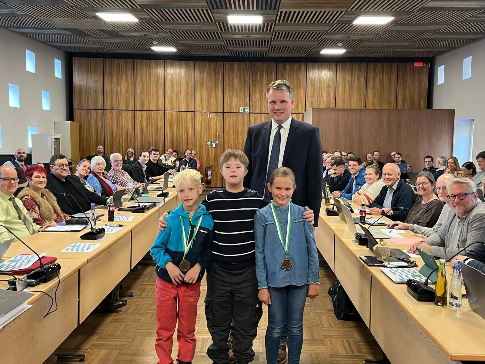 Vier Personen bei einer Ratssitzung: die Kinderbürgermeister Leonard Borgmann, Vincent Becker und Madita Noth sowie Bürgermeister Tobias Stockhoff.