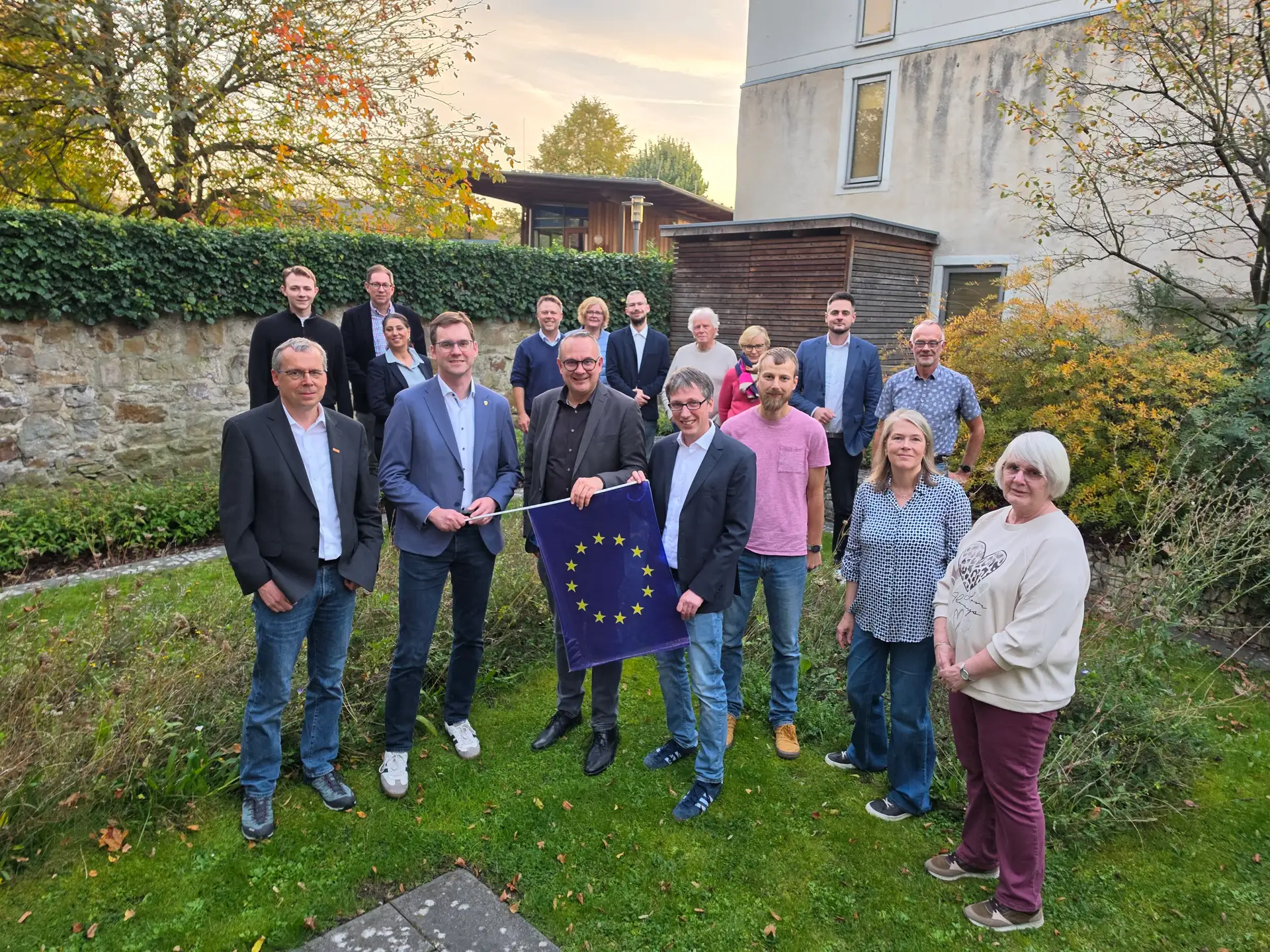 Mitglieder der Lokalen Aktionsgruppe stehen bei einer symbolischen Übergabe der Europafahne an den neuen Vorsitzenden Markus Baier. In der Mitte stehen Matthias Kalkreuter, Markus Baier und Prof. Martin Hoffmann.