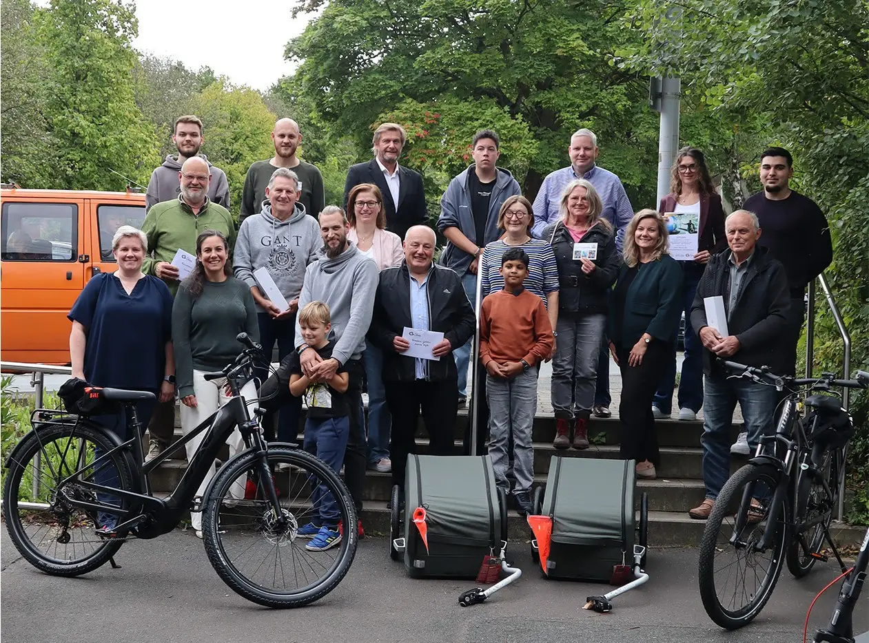 Mehrere Personen stehen gemeinsam in einer Reihe mit Fahrradmotiv/Plaketten im Rahmen der STADTRADELN-Veranstaltung; darunter sind Anna-Lena Wiebusch sowie Dennis Hetmann und Günther Weigel erkennbar.