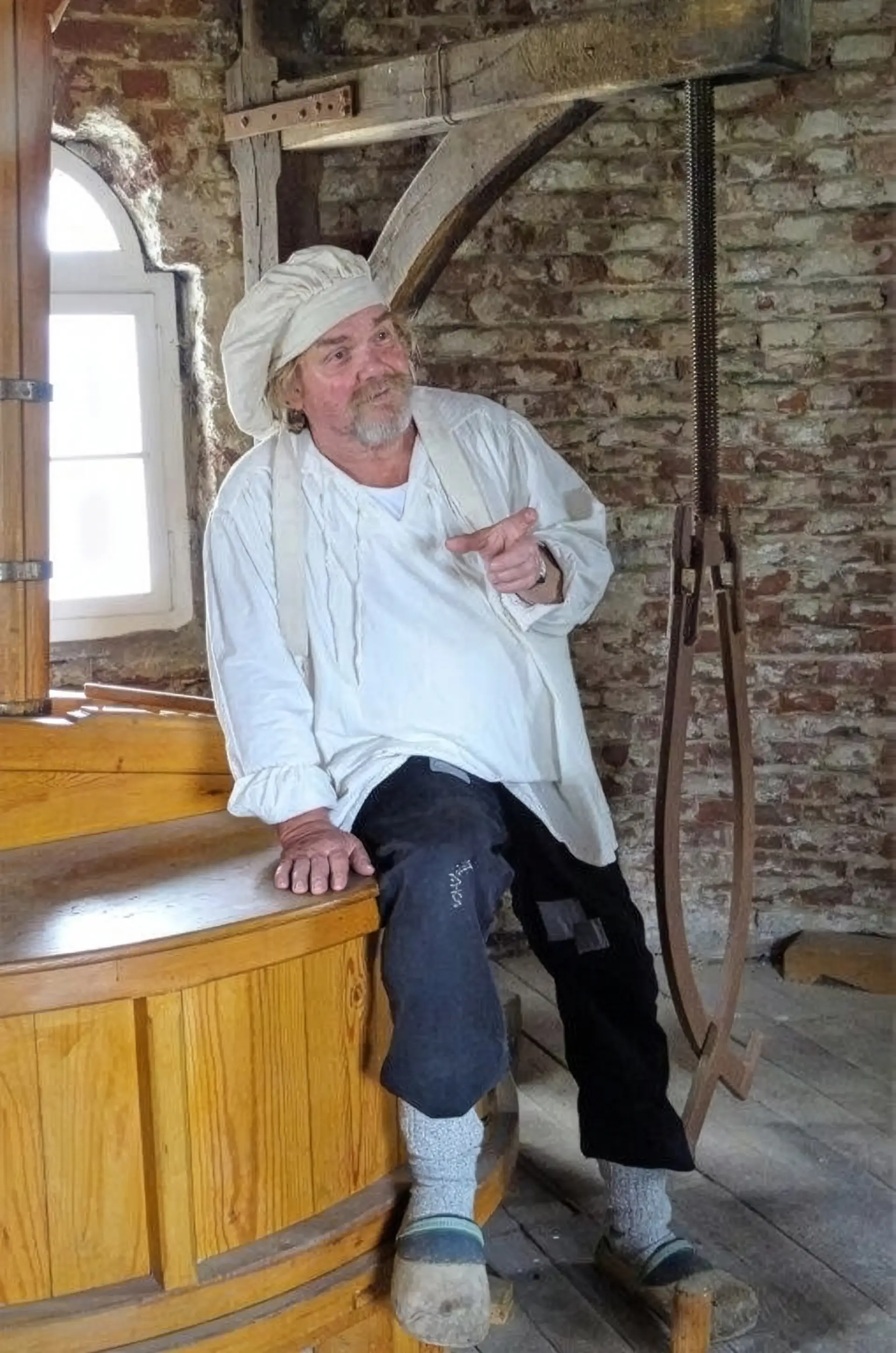 Außenaufnahme einer historischen Mühle mit angrenzendem Gebäude und Umgebung.