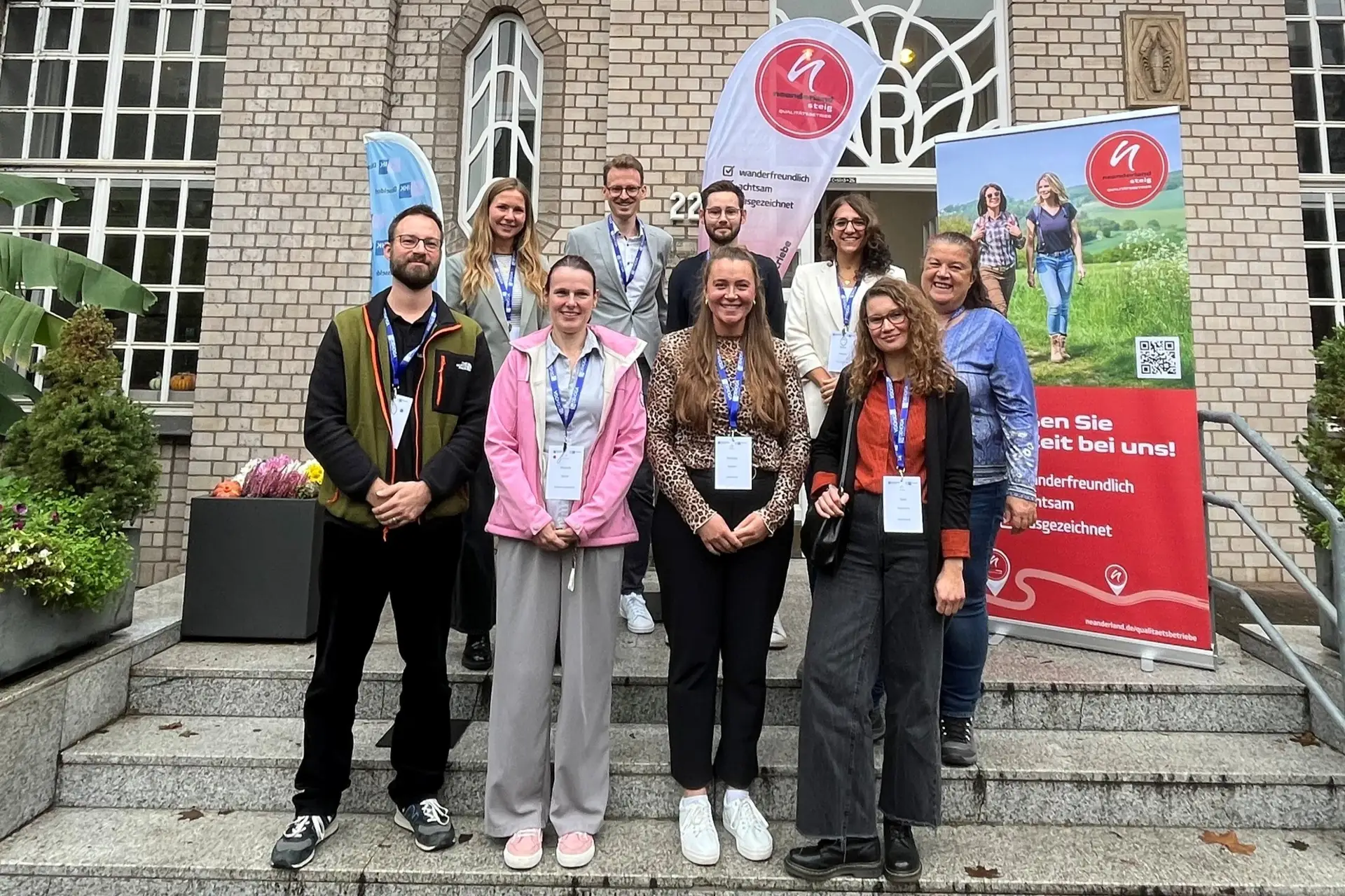 Gruppenfoto mit neun Personen in zwei Reihen.