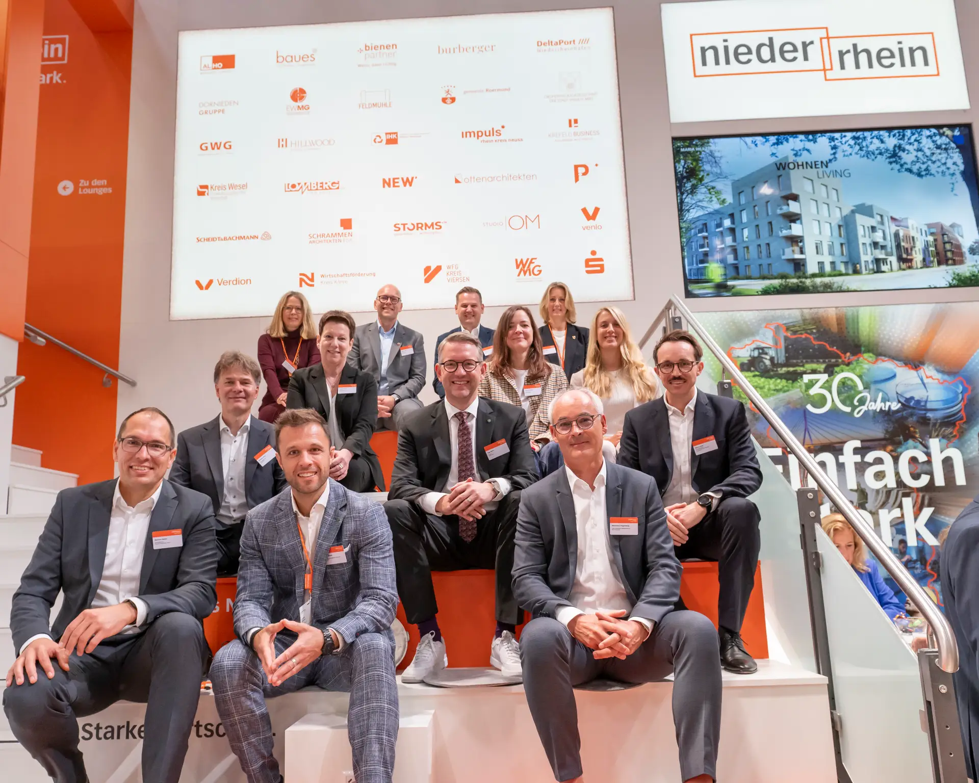 Mehrere Personen stehen auf einem Messestand und sind in einer Reihe von links nach rechts abgebildet, darunter mehrere benannte Vertreter der Stadt Wesel und weiterer Institutionen.